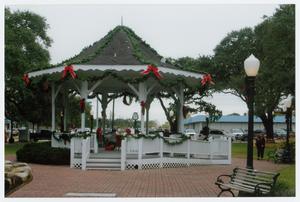 gazebo decorated with green swags and red bows
