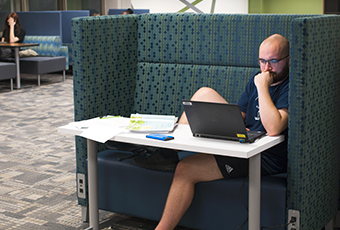 man looking at a computer screen in an individual study station