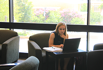 woman sitting in a chair looking at her laptop