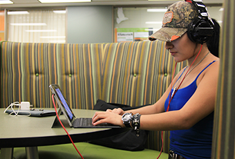 woman with headphones working on her laptop